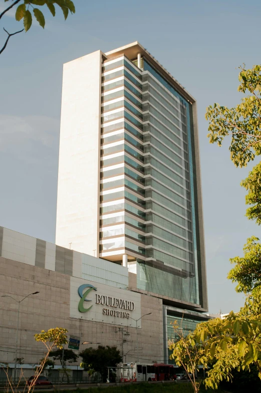 a tall building sitting on top of a lush green field, by Enguerrand Quarton, barcelo tomas, boulevard, elevation, frontal view