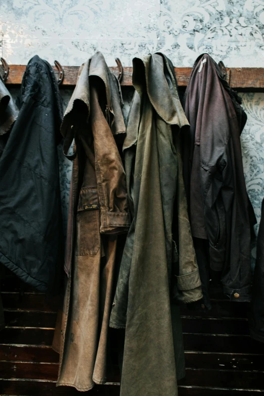 a bunch of jackets hanging up against a wall, unsplash, renaissance, dark brown duster, hunting, inside a shed, breeches