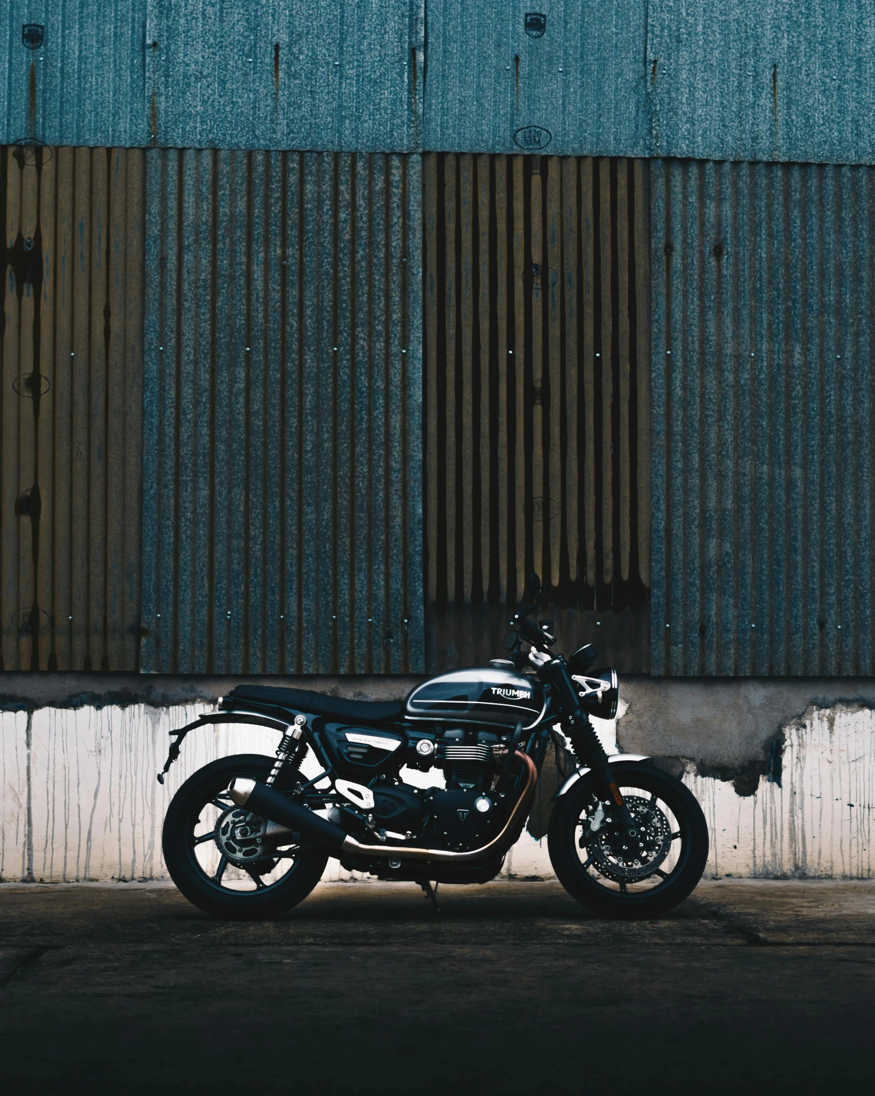 a motorcycle parked in front of a building, by Tom Bonson, pexels contest winner, metal cladding wall, triumph, profile image, plain background