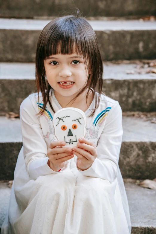 a little girl that is sitting on some steps, a child's drawing, inspired by Nara Yoshitomo, pexels contest winner, portrait of a sugar skull, cardboard, ready to model, white