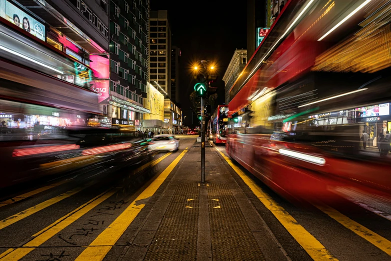 a blurry picture of a city street at night, by Matt Stewart, pexels contest winner, hyperrealism, buses, a still of kowloon, red and yellow light, motion photo