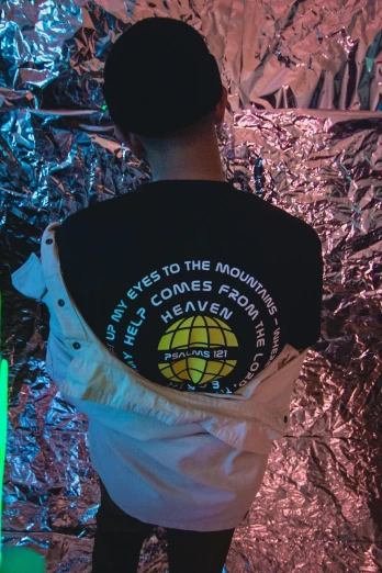 a man standing in front of a wall covered in tin foil, inspired by David LaChapelle, unsplash contest winner, holography, wearing a black t-shirt, with earth in the background, in a nightclub, wearing a patch over one eye