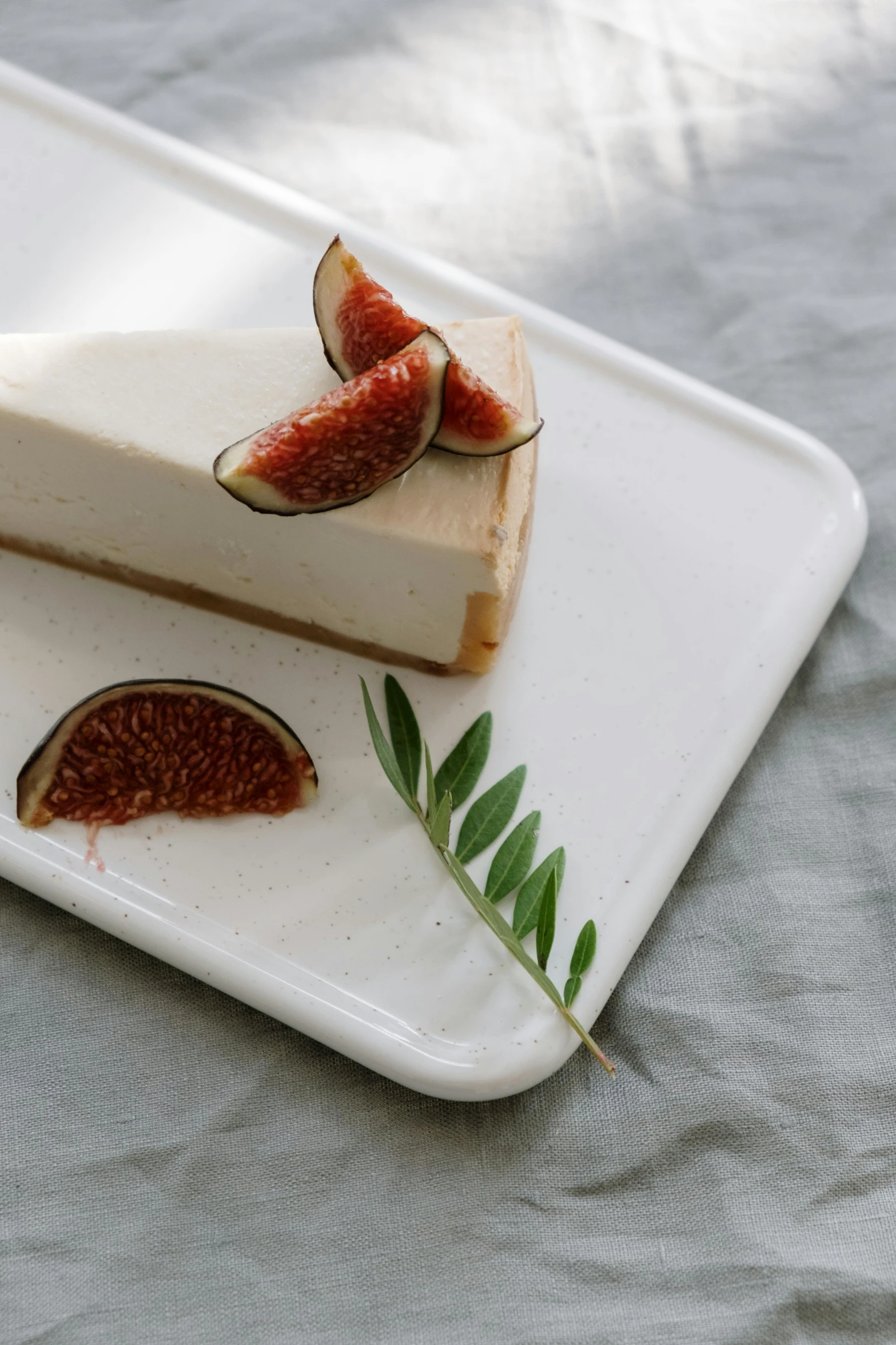 a slice of cheesecake with figs on a plate, a still life, trending on pexels, organic ceramic white, eucalyptus, f4”