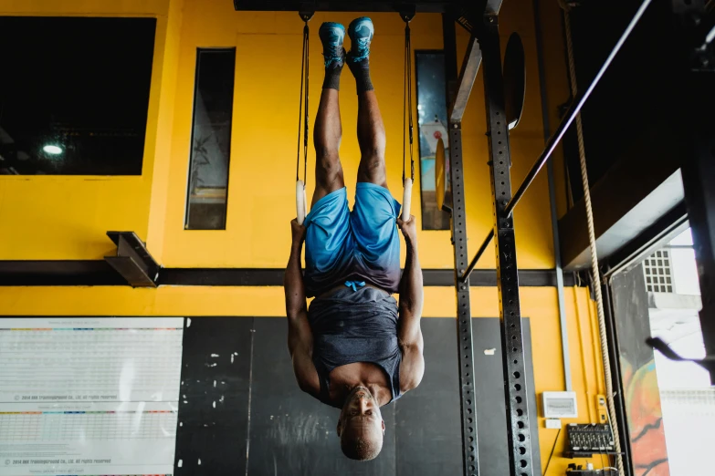 a man doing a handstand in a gym, a portrait, by Jessie Algie, pexels contest winner, hurufiyya, hanging rope, obunga, on a yellow canva, athletic crossfit build