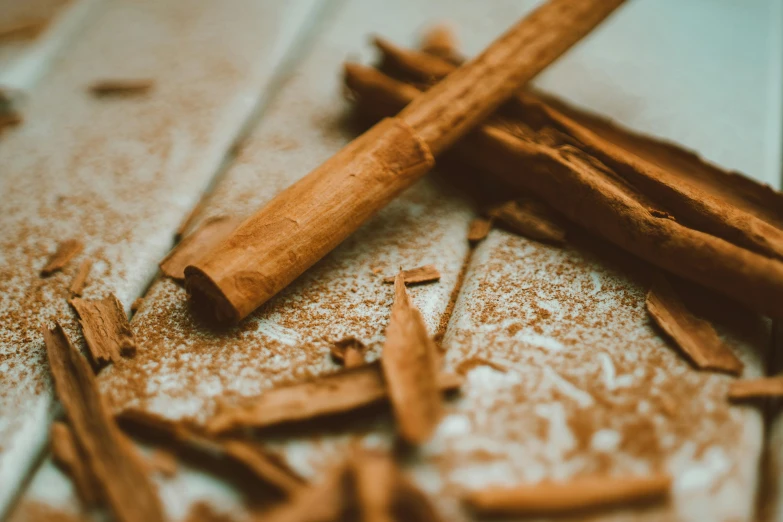 a pile of cinnamon sticks sitting on top of a counter, a macro photograph, by Daniel Lieske, trending on pexels, renaissance, powder, holding a wooden staff, ilustration, carson ellis