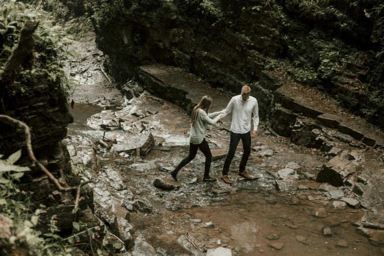 a man and a woman walking through a forest, inside a gorge, photoshoot, cornell, a high angle shot