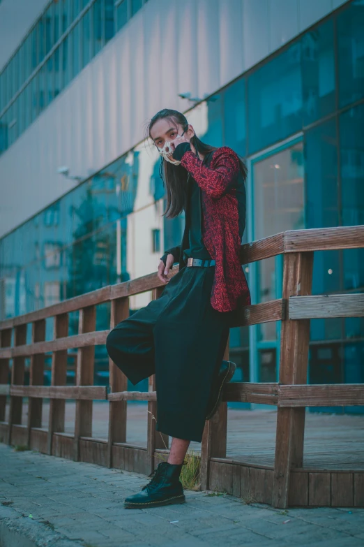 a woman talking on a cell phone in front of a building, black and red jacket, unsplash photo contest winner, striking a pose, bridge