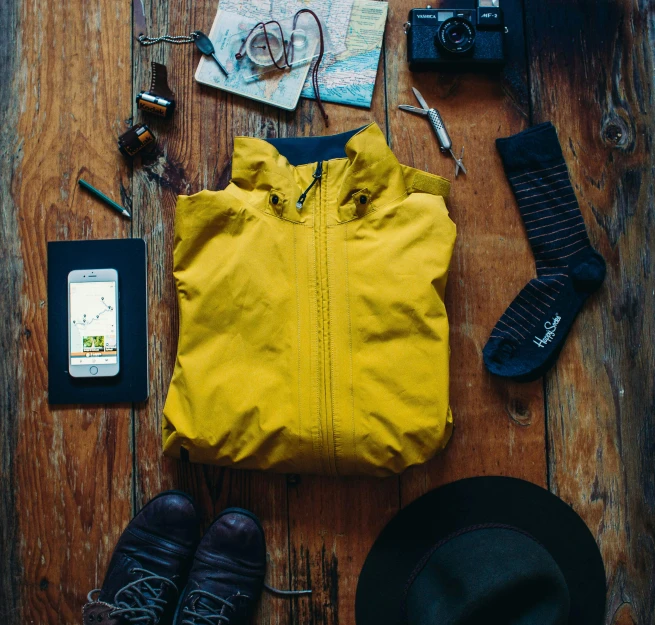 a yellow jacket sitting on top of a wooden floor, pexels contest winner, adventure gear, flatlay, hiking clothes, on display