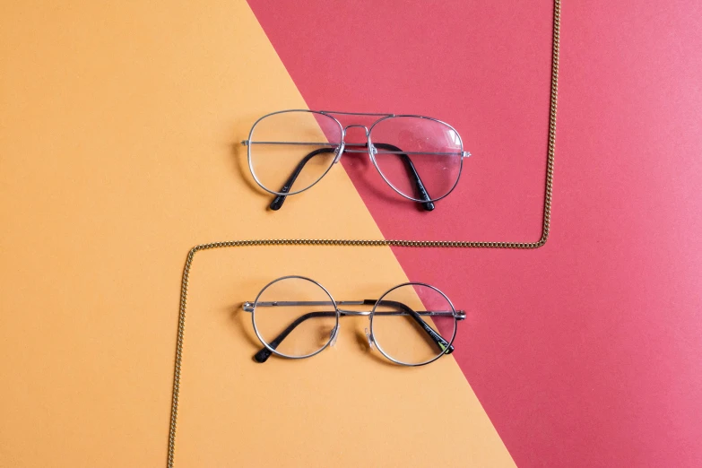 a couple of glasses sitting on top of a colorful surface, inspired by Leo Leuppi, trending on pexels, featuring rhodium wires, flat lay, harry potter style, various angles