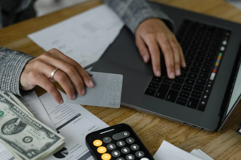 a person sitting at a desk with a laptop and a calculator, a screenshot, pexels contest winner, hurufiyya, cost, 15081959 21121991 01012000 4k, brown, realistic »