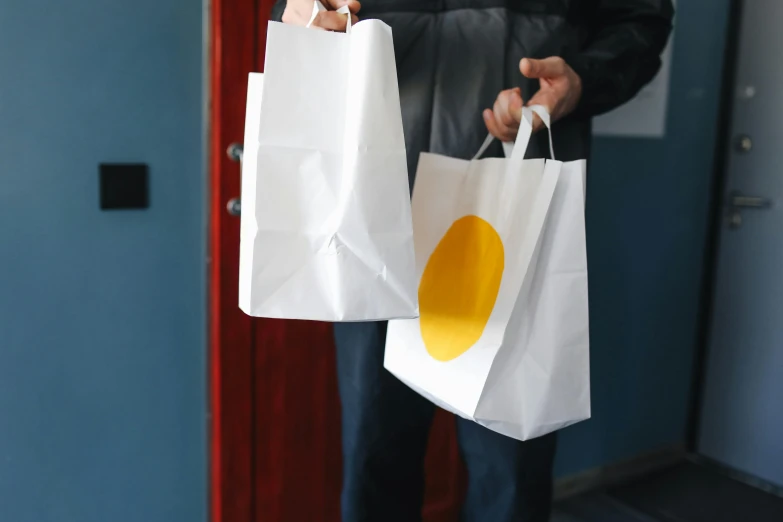 a person holding two shopping bags in their hands, pexels, private press, white and yellow scheme, restaurant, diecut, pack