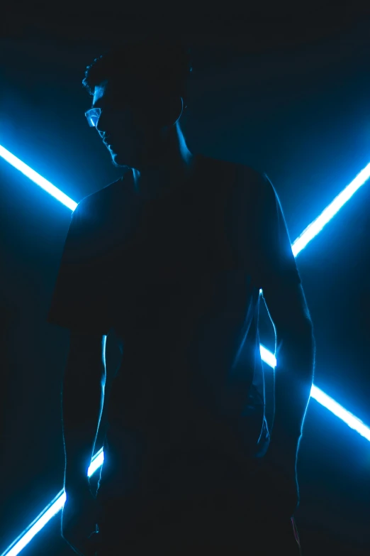 a man standing in front of neon lights, high contrast studio lighting, black and blue, dark. no text, neon cross
