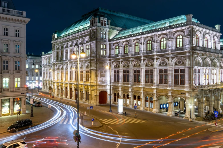 a city street filled with lots of traffic next to tall buildings, a photo, pexels contest winner, viennese actionism, vienna state opera house, at nighttime, profile image, square