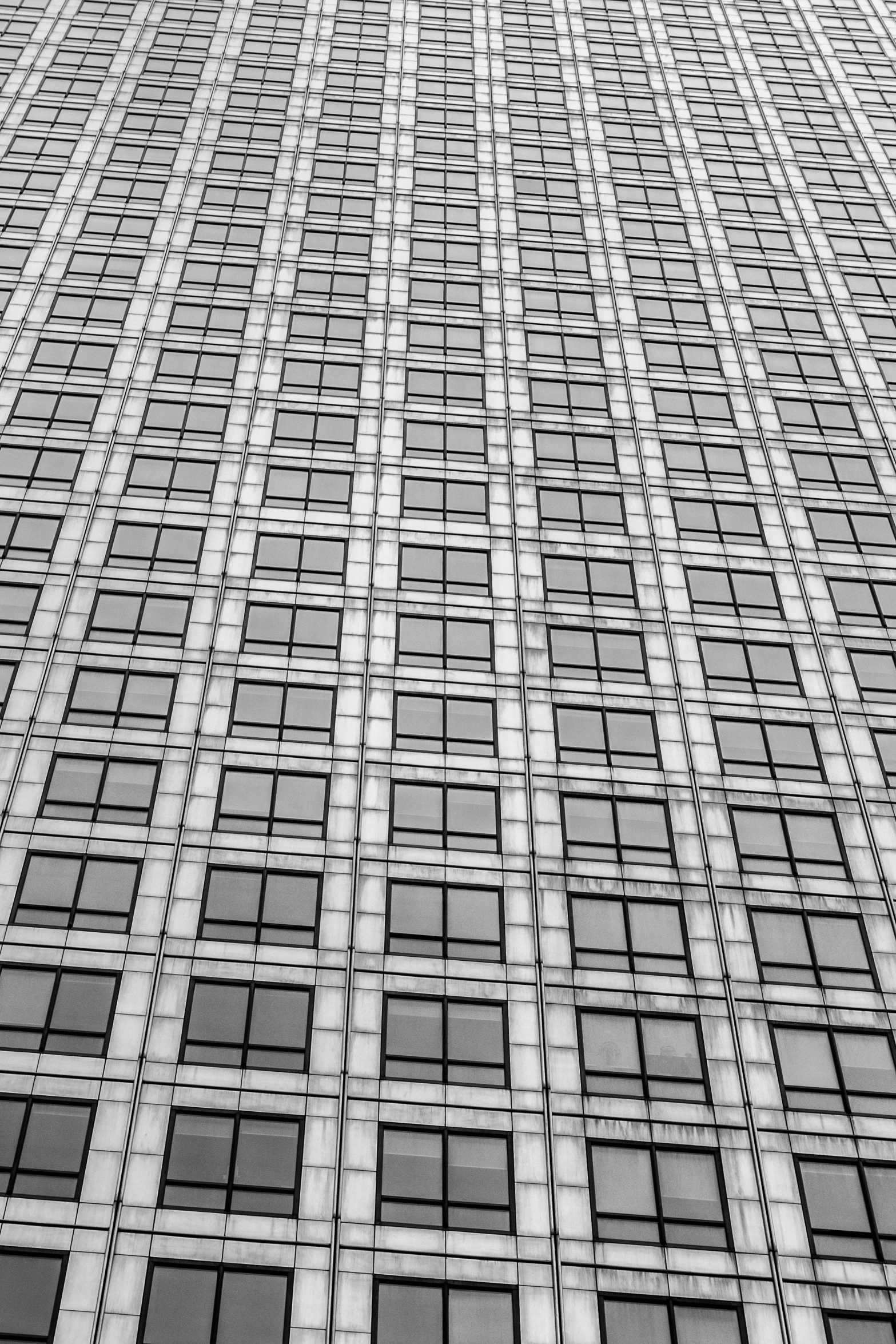 a black and white photo of a tall building, inspired by Andreas Gursky, unsplash, full of glass. cgsociety, square facial structure, squares, window ( city )