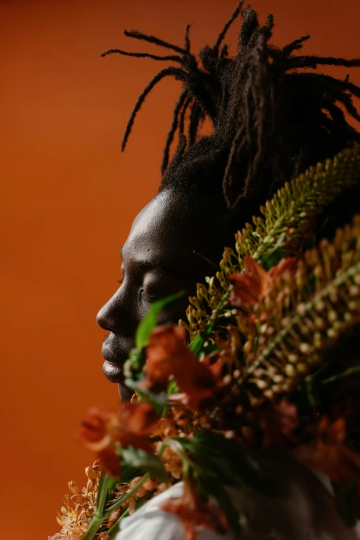 a man with dreadlocks holding a bunch of flowers, an album cover, by Winona Nelson, pexels contest winner, afrofuturism, black and terracotta, close - up profile, woman made of plants, shot on sony a 7