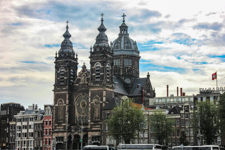 a group of buses driving down a street next to tall buildings, a photo, by Frederik Vermehren, pexels contest winner, baroque, gothic church background, square, amsterdam, with great domes and arches