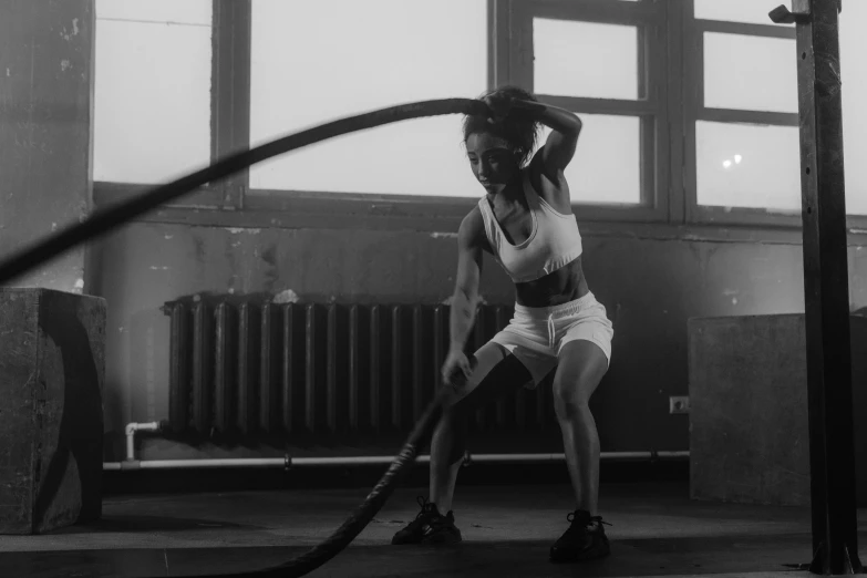 a woman holding a rope in a gym, a black and white photo, by Emma Andijewska, pexels contest winner, rubber hose animation, 🤬 🤮 💕 🎀, photo of a black woman, sport