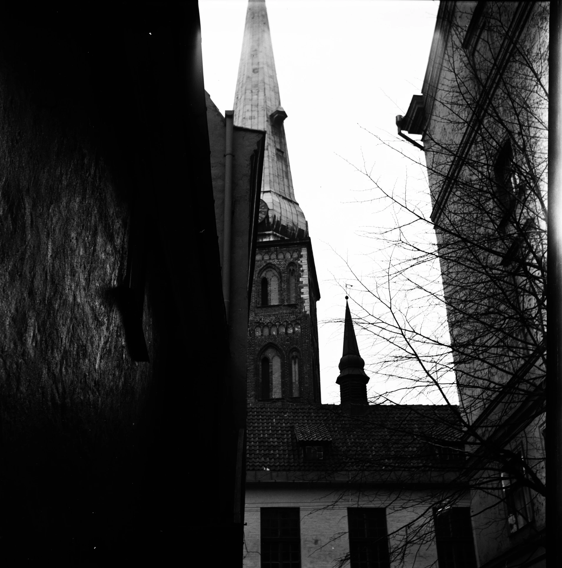 a black and white photo of a church steeple, by Adam Rex, holga hasselblad, helsinki, in an alley, ffffound