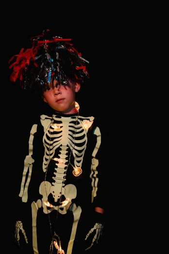 a young boy dressed up in a skeleton costume, an album cover, pexels, exquisite corpse, lit up, taken in the late 2010s, concert