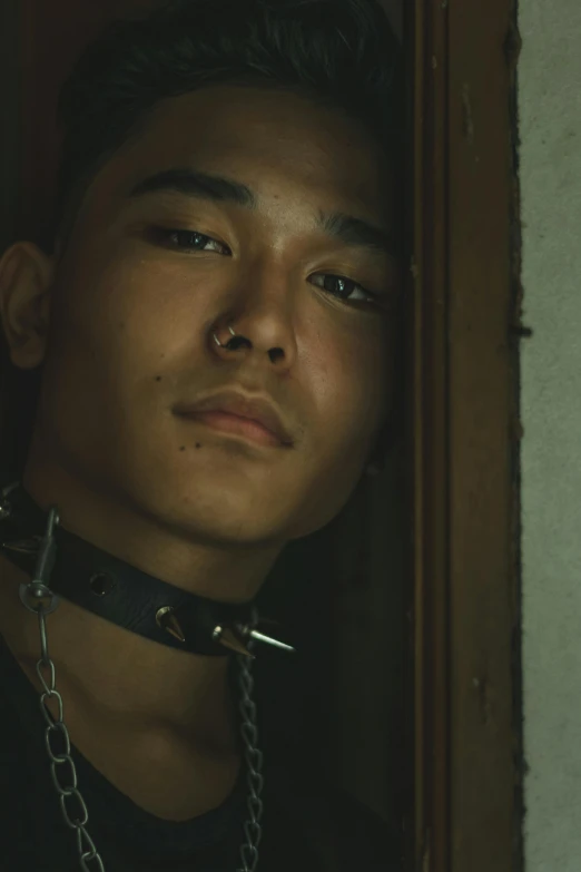 a man with a chain around his neck, inspired by Oka Yasutomo, unsplash, shin hanga, perfectly lit. movie still, lgbtq, in jail, asian descent