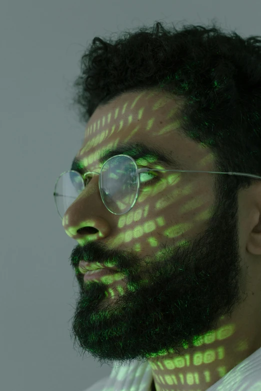 a close up of a man with glasses and a beard, inspired by Ahmed Yacoubi, holography, skin painted with green, projection mapping, aida muluneh, he has a 5 o'clock shadow