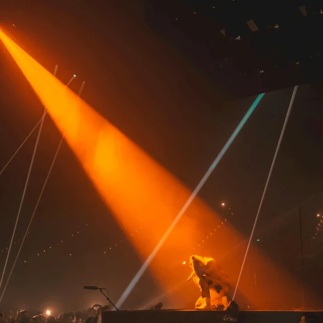 a group of people standing on top of a stage, glowing orange lasers, tyler, from the distance, long orange hair floating on air