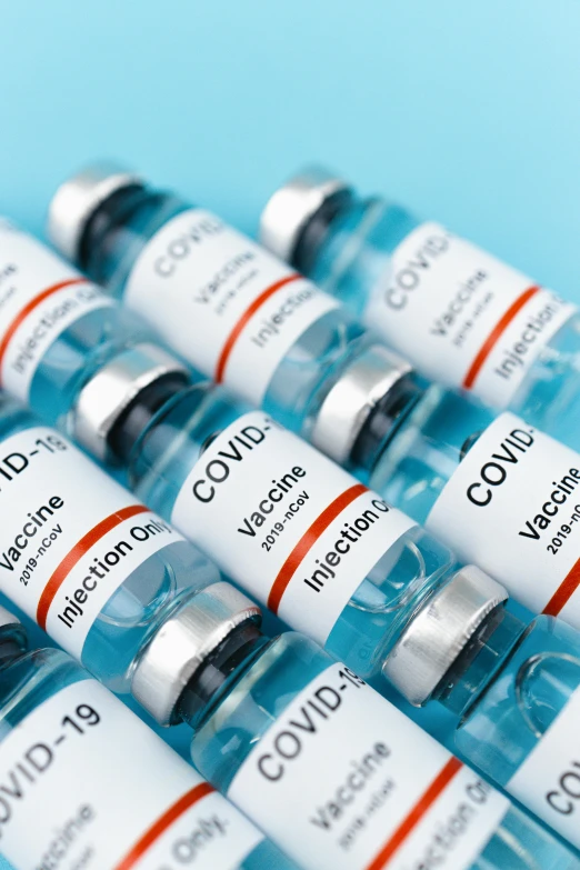 several vials of covidd vaccine on a blue surface, thumbnail, showcase, medical labels, 64x64