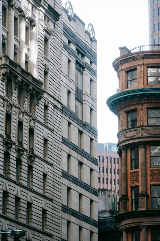 a couple of buildings that are next to each other, a photo, by Nina Hamnett, unsplash contest winner, louis sullivan, old city, half turned around, medium close up shot