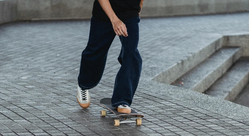 a man riding a skateboard down a sidewalk, pexels contest winner, large pants, wearing a dark shirt and jeans, casual game, zoomed out