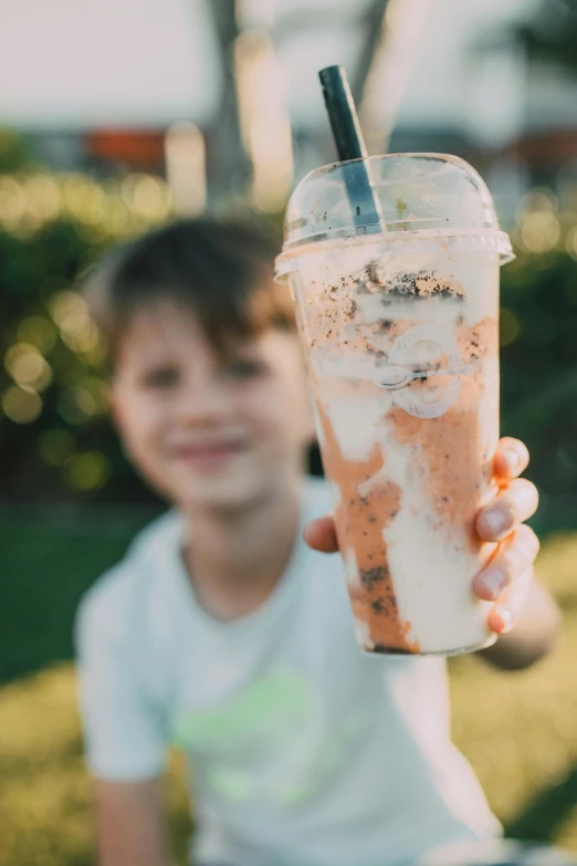 a close up of a person holding a drink, kids, milkshake, profile image, thumbnail