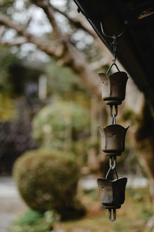 a bunch of bells hanging from the side of a building, by Yasushi Sugiyama, unsplash, mingei, in japanese garden, portrait photo, made of glazed, pot