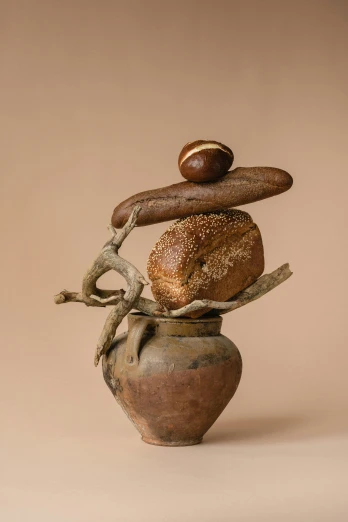 a stack of bread sitting on top of a vase, a surrealist sculpture, inspired by Hendrik Gerritsz Pot, seeds, twisted trunk, voluptuous sesame seed bun, brown bread with sliced salo