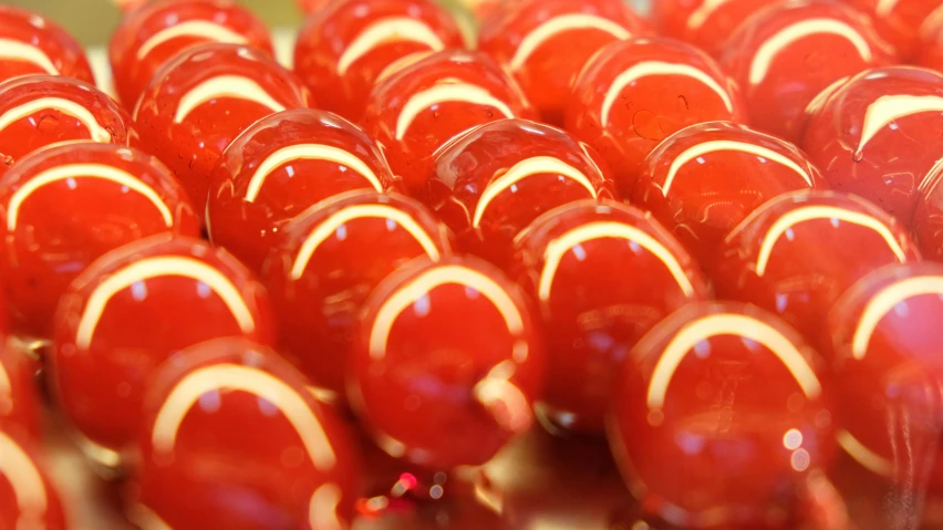 a bunch of red candies sitting on top of a table, a picture, inspired by Quirizio di Giovanni da Murano, reddit, up-close, glass shader, orange pupils, highly polished