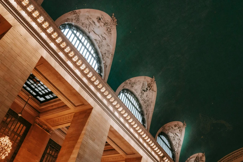 a view of the ceiling of a train station, an album cover, by Alison Geissler, unsplash contest winner, ornate palace made of green, met gala, pointed arches, photo taken at night