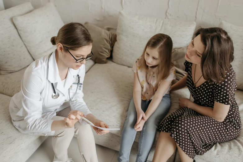 a woman and two little girls sitting on a couch, pexels, antipodeans, medical doctor, avatar image