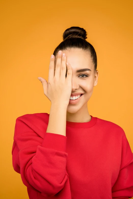 a woman covering her eyes with her hands, shutterstock contest winner, minimalism, smiling fashion model, red yellow, portrait sophie mudd, large pores