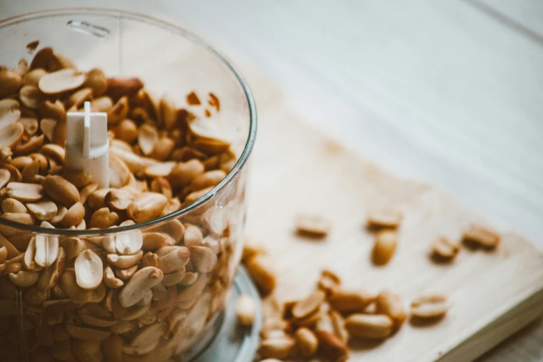 a food processor filled with peanuts on top of a cutting board, by Julia Pishtar, trending on pexels, avatar image, background image, dessert, nuttavut baiphowongse
