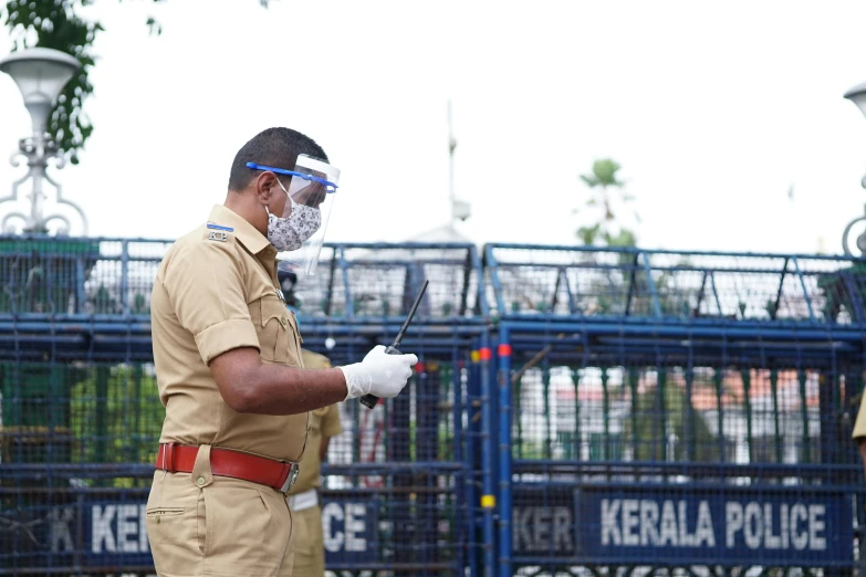 two police officers standing in front of a gate, happening, with kerala motifs, coronavirus, inspect in inventory image, thumbnail