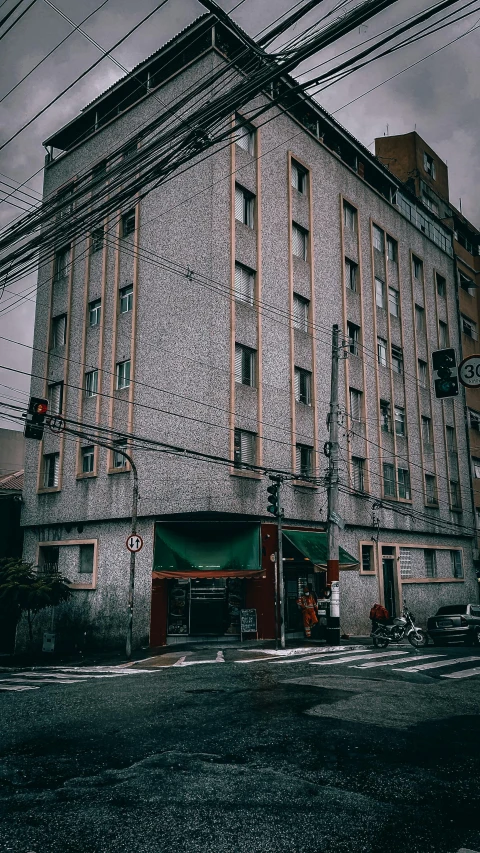 a tall building sitting on the side of a road, a colorized photo, unsplash, shin hanga, old apartment, on a rainy day, desaturated!!, gif