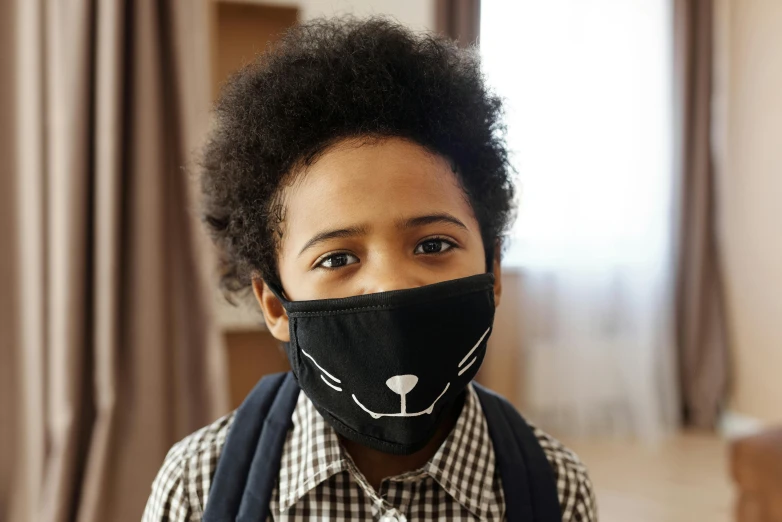 a close up of a child wearing a face mask, by Paul Bird, black curly beard, face accessories, garfield cat face, schools