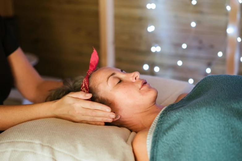 a woman getting a massage at a spa, a portrait, by Jessie Algie, unsplash, straya, halo over her head, laying on a bed, seasonal