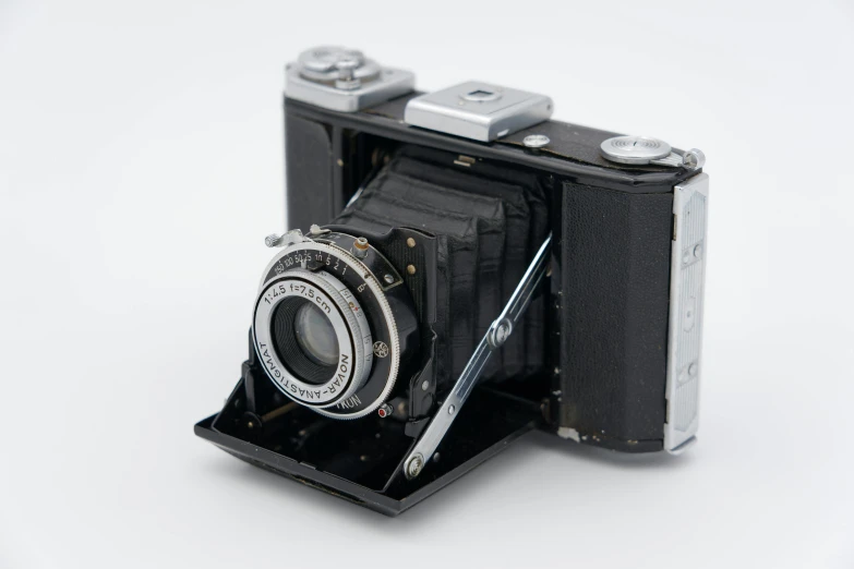 a close up of a camera on a white surface, by Niels Lergaard, bauhaus, f/3.5, ultra high quality model, well detailed, very old