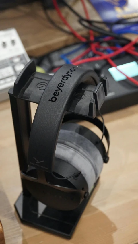 a pair of headphones sitting on top of a wooden desk, by Kev Walker, polycount contest winner, hurufiyya, ap press photo, straps, overclocking, bl