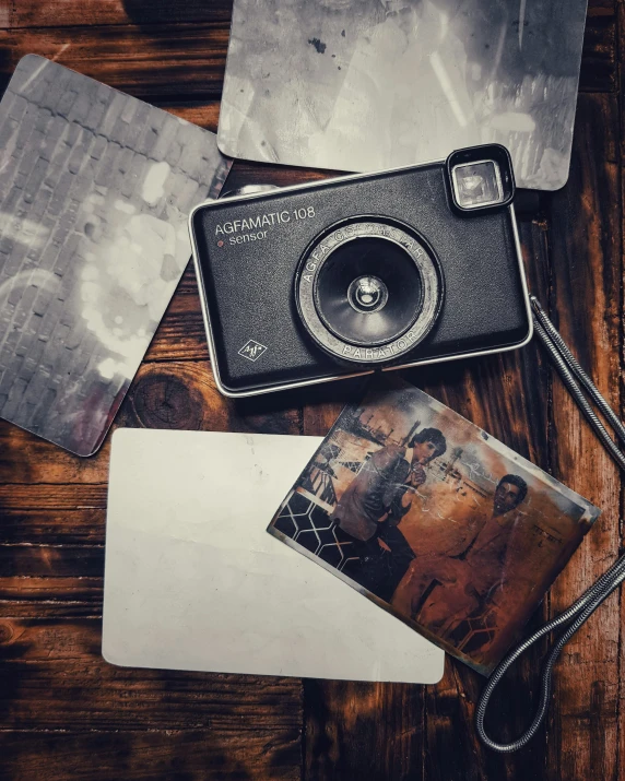 a camera sitting on top of a wooden table, a polaroid photo, metal plate photograph, scratched photo