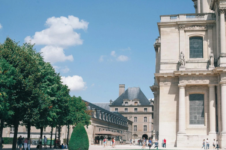 a large building with a fountain in front of it, inspired by Adélaïde Victoire Hall, trending on unsplash, paris school, an archway, looking across the shoulder, summer day, in a square