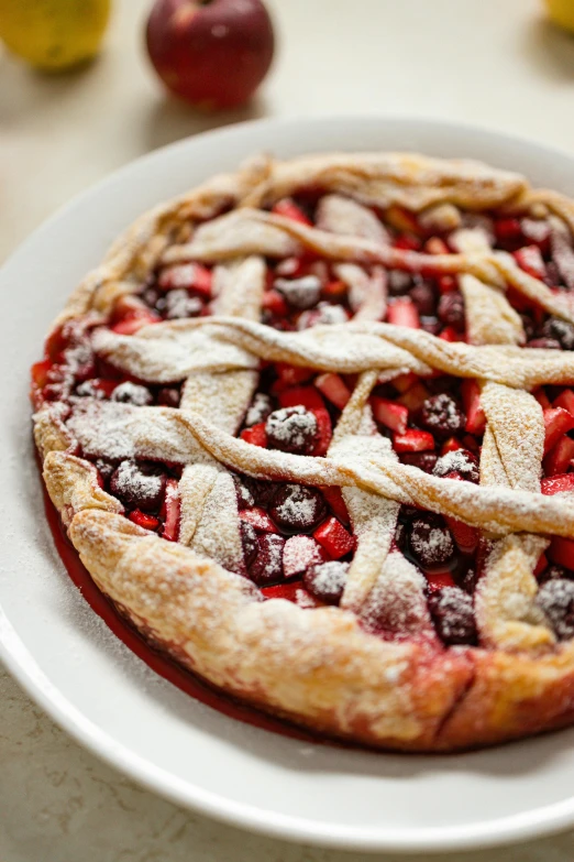 a pie sitting on top of a white plate, red and purple, fruit, covered in white flour, cross hatch