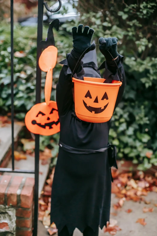 a little boy dressed up in a halloween costume, by Nicolette Macnamara, pexels, hanging lanterns, holding a crowbar, with no face, detail shot