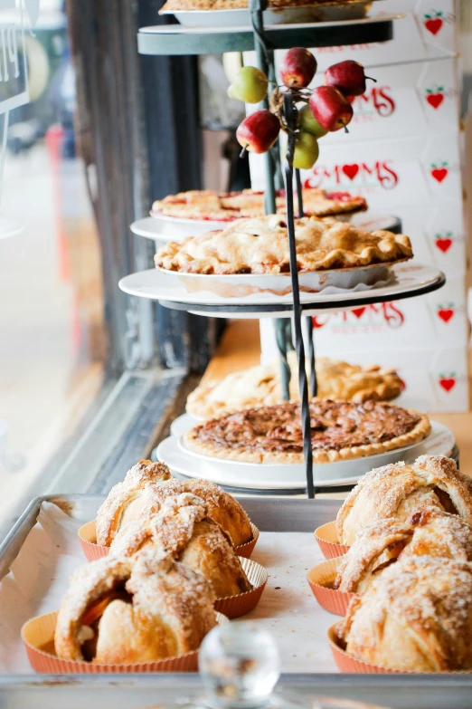 a display case filled with lots of different types of pies, unsplash, hearts, sunny day time, apples, tree's