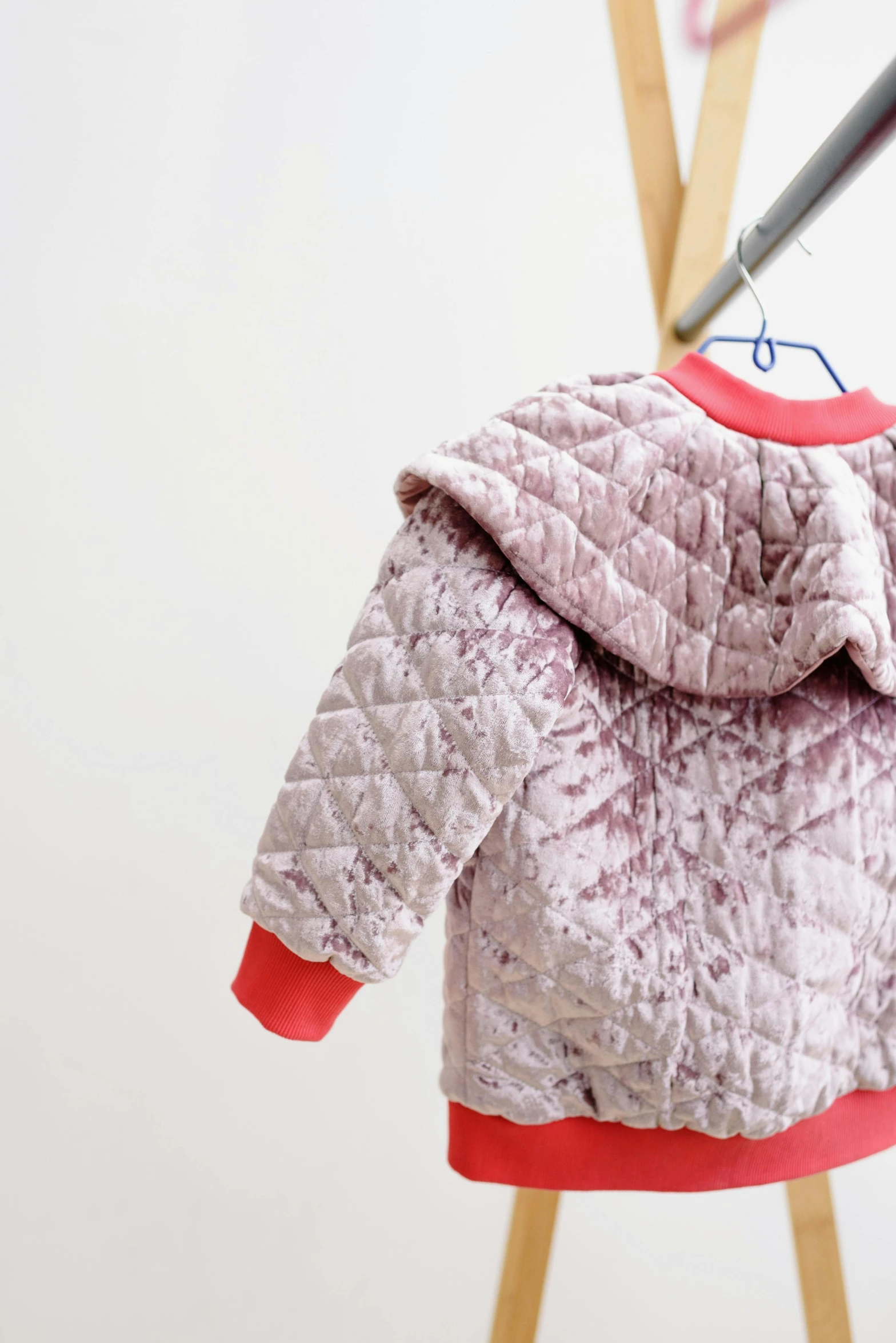 a teddy bear coat hanging on a clothes rack, by Nina Hamnett, unsplash, process art, wearing a pink hoodie, textured base ; product photos, soft grey and red natural light, silver metallic moncler jacket