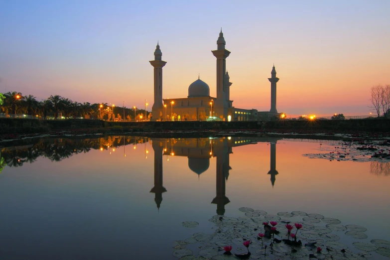 a large building sitting next to a body of water, by Basuki Abdullah, mosque, during a sunset, lagoon, festivals